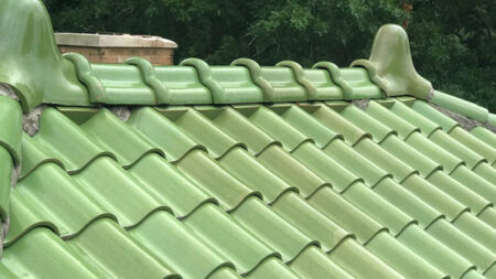 Ridge of a glazed clay tile roof in green
