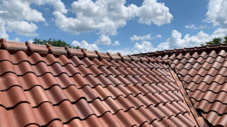 Peak of a Spanish clay tile roof with blue sky
