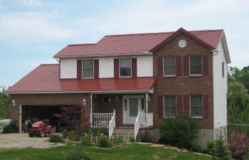 Metal Shingle roof panels in Sienna Sunset red on tri-level house