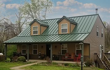 Standing seam metal roof in green on brick home
