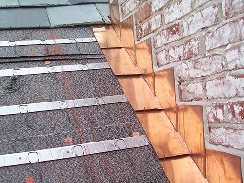Copper flashing on roof to wall transition