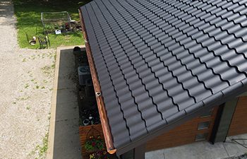 Charcoal Metal Tile roof panels with copper half-round gutters