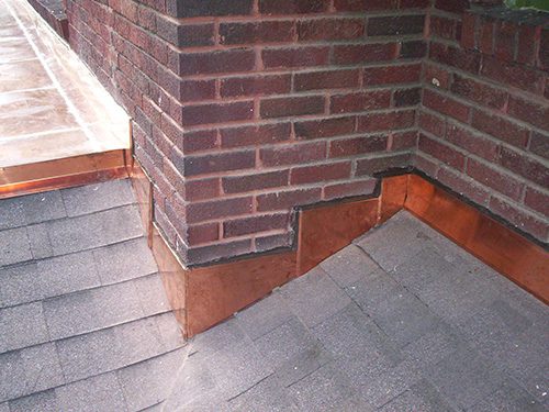 copper step flashing along wall