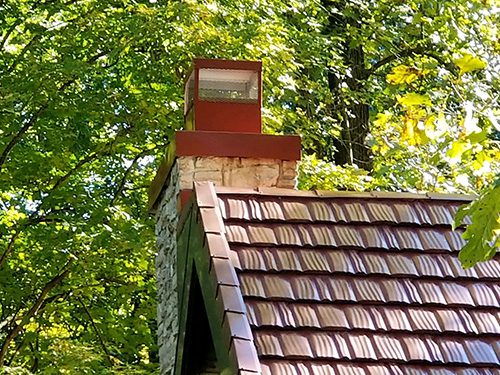 Steel chimney cap on red roof
