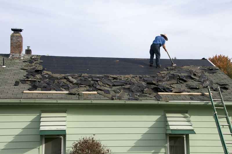 Roofers replacing storm-damaged shingles on a home in Indianapolis